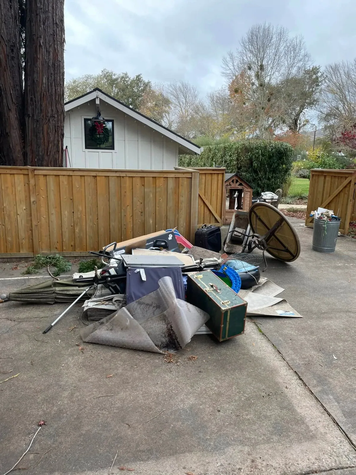 Outdoor furniture and unwanted household items beside a gate
